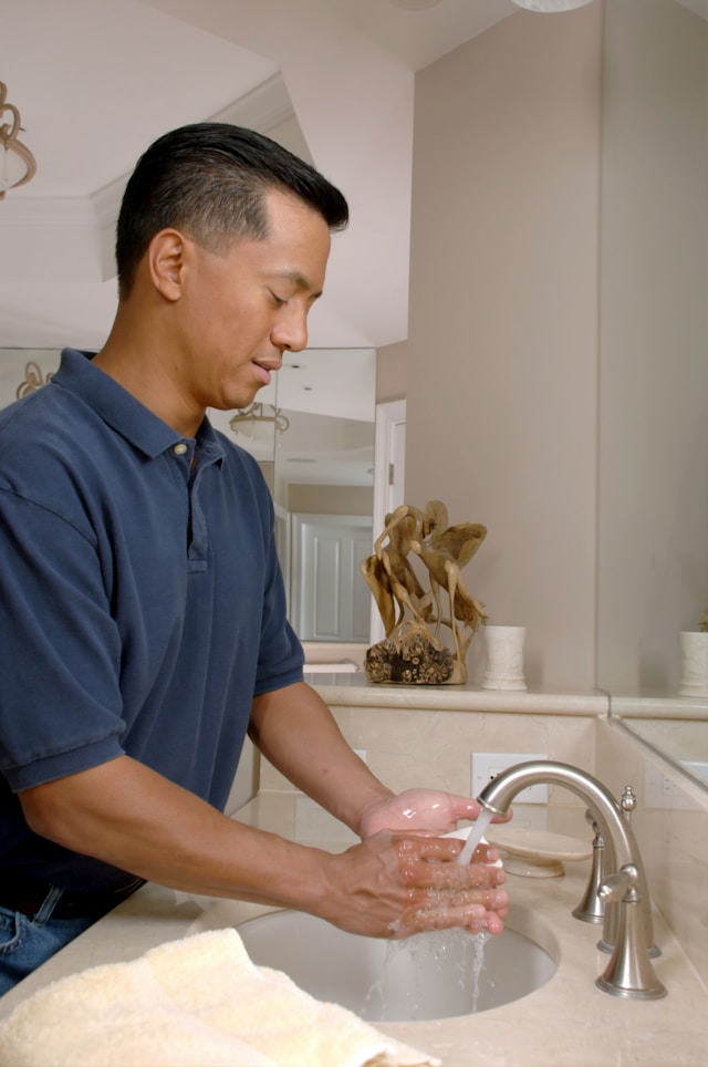 man washing hands in a sink